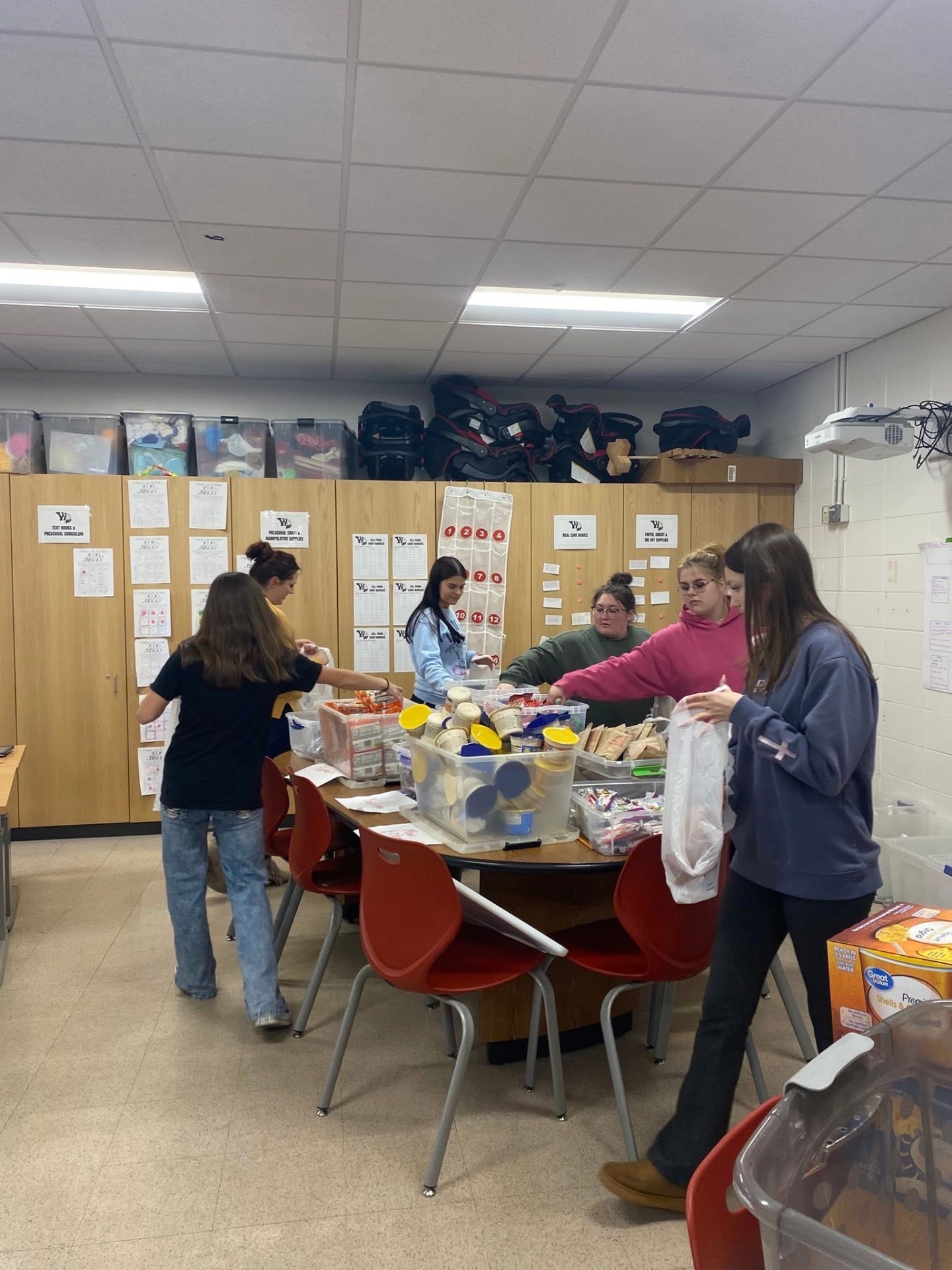 A team filling care packs together at round tables